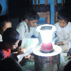 Children sitting around a solar lamp Children sitting around a solar lamp